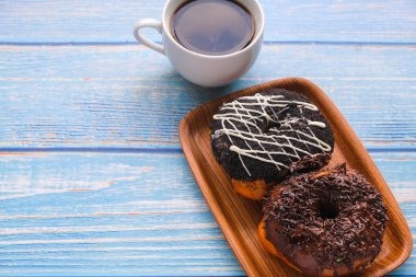 Tahta masada bir fincan kahveyle taze çörek..