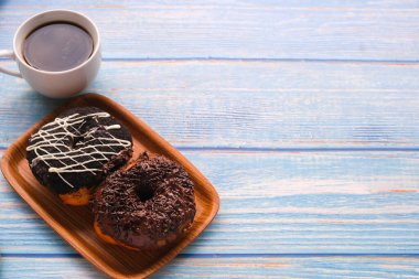 Tahta masada bir fincan kahveyle taze çörek..