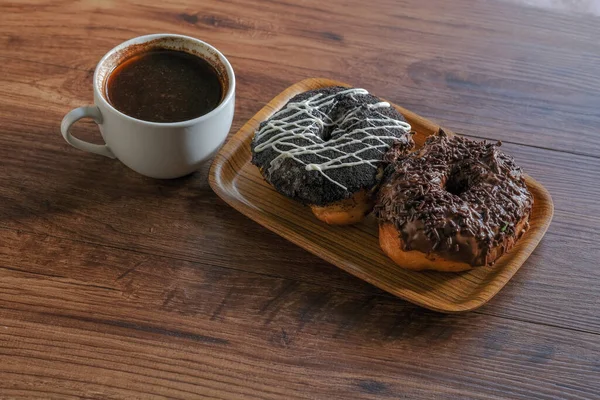 木桌上有新鲜的甜甜圈和一杯咖啡 — 图库照片