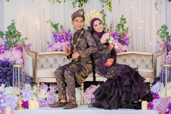 Malay düğünü için ev içi çekim, gelin ve damat geleneksel Malezya giysisi giyiyor. Mutlu Aile Kavramı