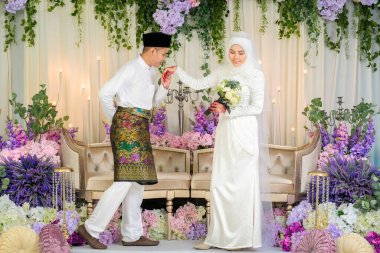 Indoor shooting for Malay wedding, the bride and groom wearing Malay traditional  cloth in marriage ceremony . Happy & Family Concept clipart
