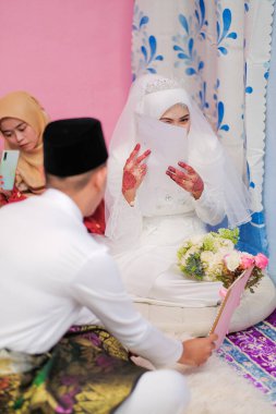 Müslüman bir gelin resmileştiriliyor. Malezya Geleneksel Düğünü. İslami bir düğünde en önemli şey Nikah törenidir..