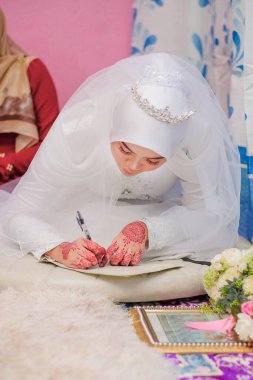 Müslüman bir gelin resmileştiriliyor. Malezya Geleneksel Düğünü. İslami bir düğünde en önemli şey Nikah törenidir..