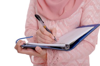 Başörtüsü takmış, gülümseyen ve kitap tutan oldukça modern bir Asyalı kadın..