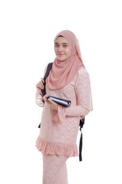 Sırt çantalı, gülümseyen ve kitap tutan oldukça modern Asyalı kadın..