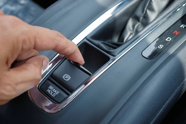 Modern bir arabadaki elektronik park freni (EPB) düğmesine yakın çekim.