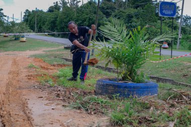 Muadzam Şah, Malezya - 22 Kasım 2020: Bölge sakinleri göl kenarını temizlemek ve temizlemek için birbirlerine takım çalışması ruhuyla yardım ediyorlar. İnsanlar peyzaj işleri yapıyor. .