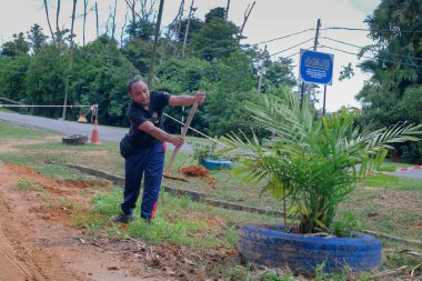 Muadzam Şah, Malezya - 22 Kasım 2020: Bölge sakinleri göl kenarını temizlemek ve temizlemek için birbirlerine takım çalışması ruhuyla yardım ediyorlar. İnsanlar peyzaj işleri yapıyor. .