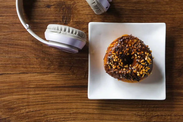 Kulaklıklı lezzetli çörekler ve ahşap masada bir fincan kahve.