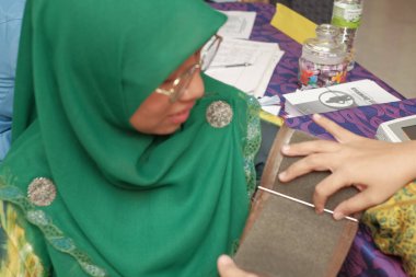 Muadzam Şah - Malezya - 25 Temmuz 2019: Kadın doktor veya eczacı, FEerkek bir hastanın tansiyonunu ölçüyor.