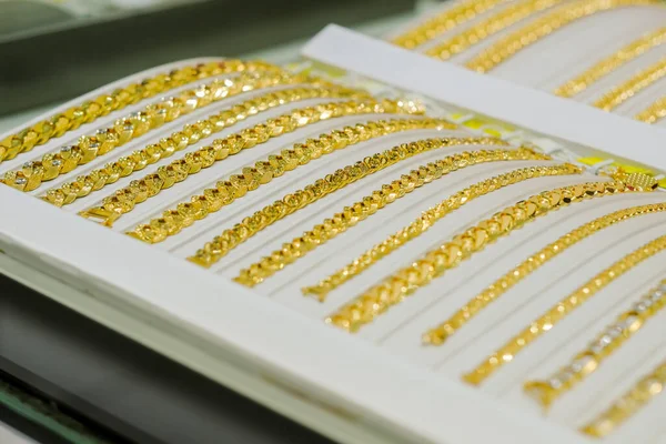 Yüzüklü, bilezik ve kolyeli altın mücevher mağazası vitrininde