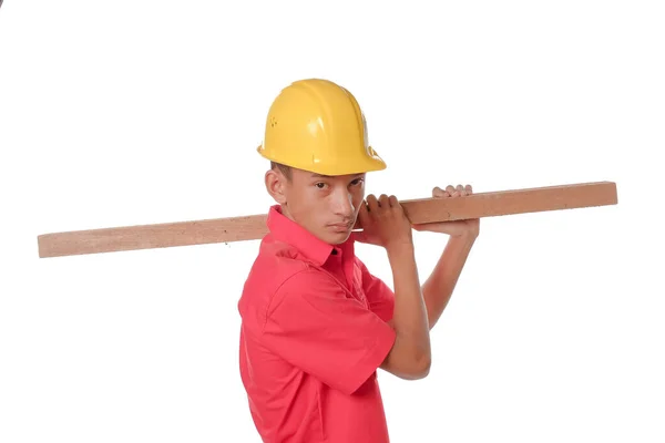 建筑工人肩上扛着木板 木匠头戴白色背景隔离的安全帽 防护设备概念 — 图库照片