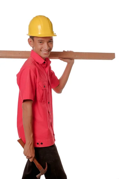 Trabajador Construcción Llevando Una Tabla Madera Hombro Sosteniendo Martillo Carpintero —  Fotos de Stock