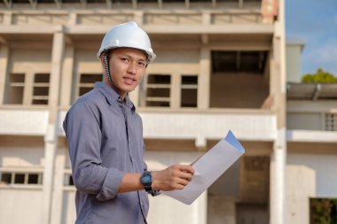 İnşaat alanındaki belgelerle çalışan başarılı inşaat mühendisi.