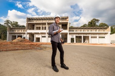 İnşaat alanındaki belgelerle çalışan başarılı inşaat mühendisi.