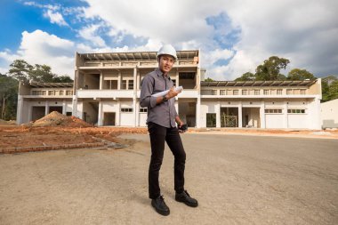 İnşaat alanındaki belgelerle çalışan başarılı inşaat mühendisi.