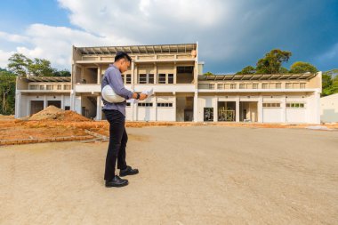 İnşaat alanındaki belgelerle çalışan başarılı inşaat mühendisi.