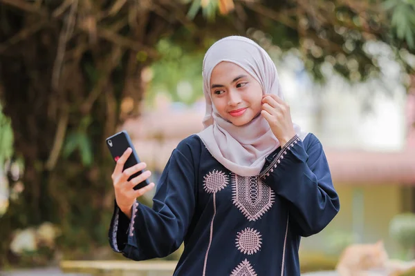 漂亮的穆斯林妇女用智能手机戴头巾的肖像 技术和交流概念 — 图库照片