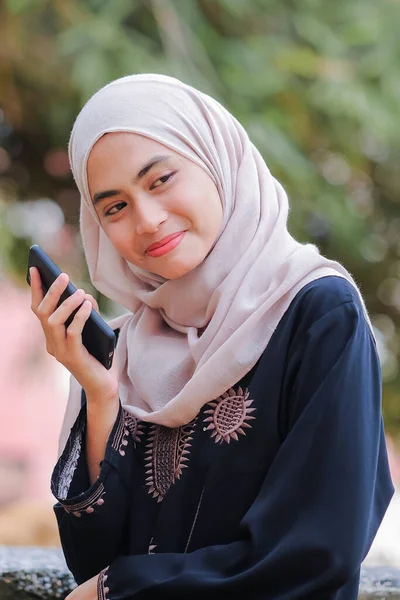 スマートフォンを使ったヒジャーブ姿の可愛いムスリム女性の肖像 技術とコミュニケーションの概念 — ストック写真