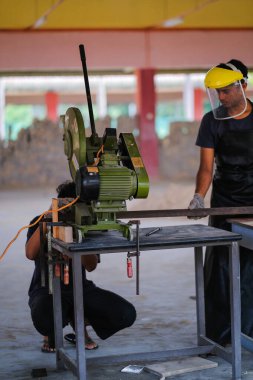 Metal plaka için disk kesici kullanan genç adam, endüstriyel ve inşaat için aletler.