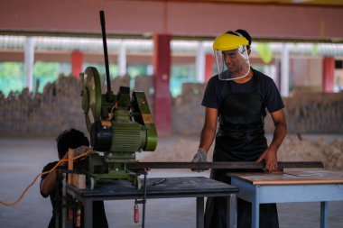 Metal plaka için disk kesici kullanan genç adam, endüstriyel ve inşaat için aletler.