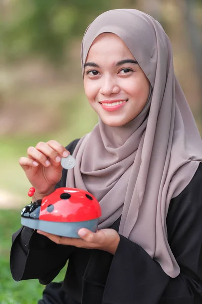 Schöne Junge Frau Mit Hijab Legt Münzen Ein Sparschwein Park — Stockfoto