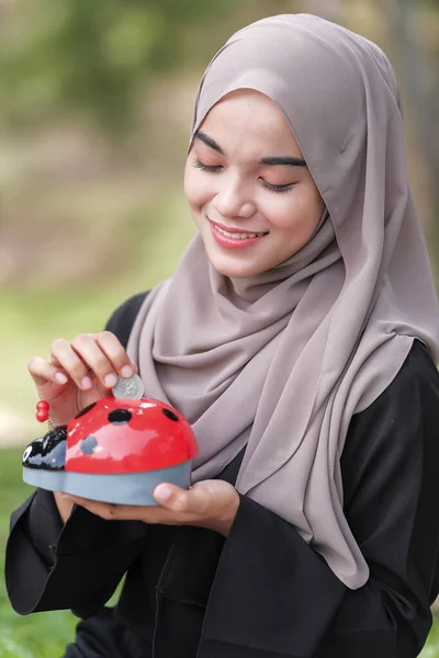 Schöne Junge Frau Mit Hijab Legt Münzen Ein Sparschwein Park — Stockfoto