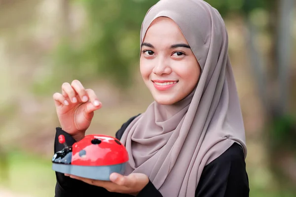 Schöne Junge Frau Mit Hijab Legt Münzen Ein Sparschwein Park — Stockfoto