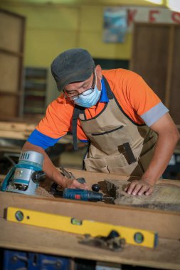 Odaklanmış profesyonel ahşap işçisinin portatif sehpa makinesi yaparken ön manzara fotoğrafı. Ahşap işçiliği ve marangozluk üretimi .