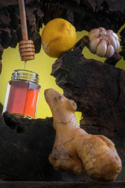 Limon, sarımsak, bal ve zencefil. Koyu sarı arka planda.