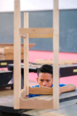 İş kıyafetleri içindeki genç marangoz atölyedeki konsol masasının bileşenlerine saldırıyor.