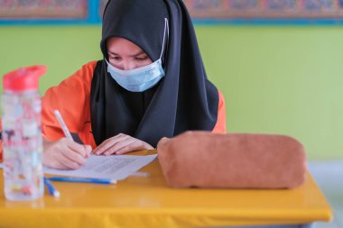 Muadzam Şah, Malezya - 20 Ocak 2021: Malezyalı öğrenciler Covid -19 'dan korunmak için sınıfta yüz maskesi ve yüz maskesi takıyorlar. Yeni normal eğitim.
