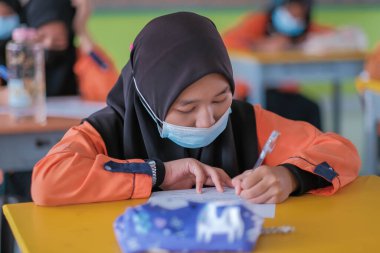 Muadzam Şah, Malezya - 20 Ocak 2021: Malezyalı öğrenciler Covid -19 'dan korunmak için sınıfta yüz maskesi ve yüz maskesi takıyorlar. Yeni normal eğitim.