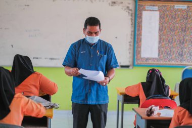 Muadzam Şah, Malezya - 20 Ocak 2021: Okul tatilinden sonra okulda maskeli öğretmen ve öğrenci MCO 2.0 - COVID-19.
