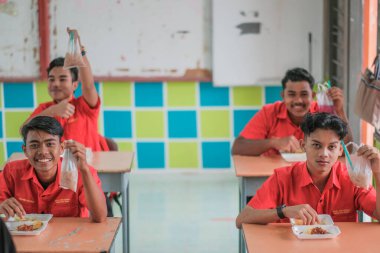 Muadzam Şah, Malezya - 20 Ocak 2021: Öğrenci sınıfta yemek yiyor. Sosyal uzaklık. Corona virüsünün ya da COVID 'nin korunmasını kabul et - 19.