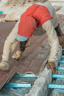 Çatı döşeyen işçiler. Bir ev çatısı, seramik fayans ya da beton çatı döşeme endüstrisi.