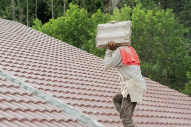 Çatı döşeyen işçiler. Bir ev çatısı, seramik fayans ya da beton çatı döşeme endüstrisi.