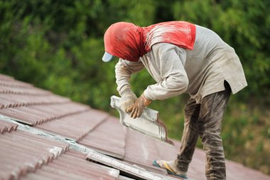 Çatı döşeyen işçiler. Bir ev çatısı, seramik fayans ya da beton çatı döşeme endüstrisi.