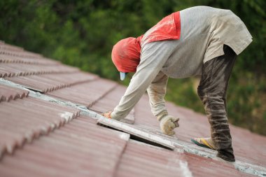 Çatı döşeyen işçiler. Bir ev çatısı, seramik fayans ya da beton çatı döşeme endüstrisi.