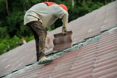 Çatı döşeyen işçiler. Bir ev çatısı, seramik fayans ya da beton çatı döşeme endüstrisi.
