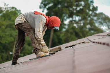 Çatı döşeyen işçiler. Bir ev çatısı, seramik fayans ya da beton çatı döşeme endüstrisi.