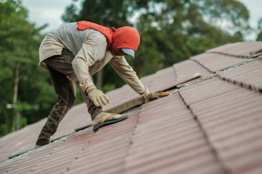 Çatı döşeyen işçiler. Bir ev çatısı, seramik fayans ya da beton çatı döşeme endüstrisi.