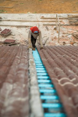 Çatı döşeyen işçiler. Bir ev çatısı, seramik fayans ya da beton çatı döşeme endüstrisi.
