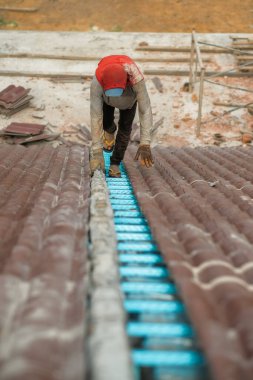 Çatı döşeyen işçiler. Bir ev çatısı, seramik fayans ya da beton çatı döşeme endüstrisi.