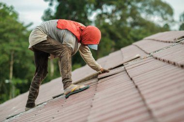 Çatı döşeyen işçiler. Bir ev çatısı, seramik fayans ya da beton çatı döşeme endüstrisi.