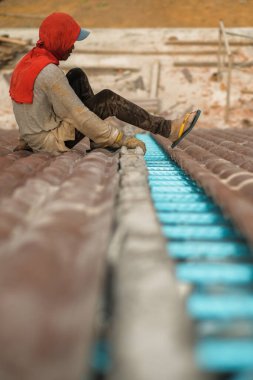 Çatı döşeyen işçiler. Bir ev çatısı, seramik fayans ya da beton çatı döşeme endüstrisi.