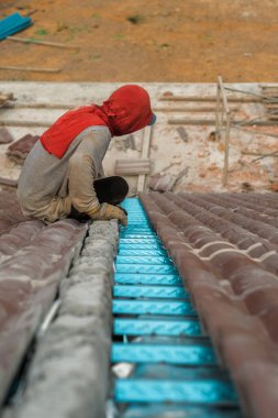 Çatı döşeyen işçiler. Bir ev çatısı, seramik fayans ya da beton çatı döşeme endüstrisi.