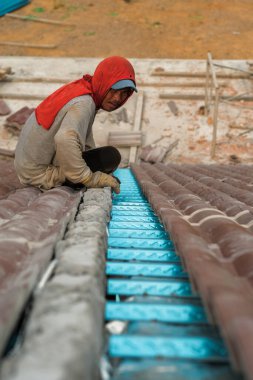 Çatı döşeyen işçiler. Bir ev çatısı, seramik fayans ya da beton çatı döşeme endüstrisi.