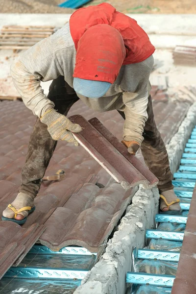 Çatı döşeyen işçiler. Bir ev çatısı, seramik fayans ya da beton çatı döşeme endüstrisi.