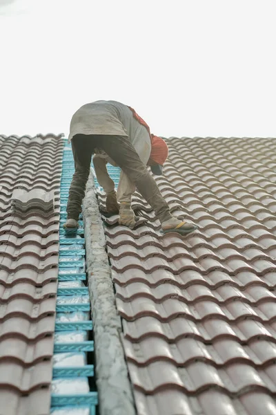 Çatı döşeyen işçiler. Bir ev çatısı, seramik fayans ya da beton çatı döşeme endüstrisi.